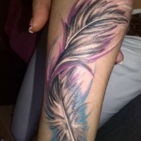 Fluffy curled colorful feather tattoo on arm