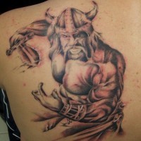 Frenzied Viking warrior with sword tattoo on back