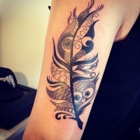 Funny black-and-white tribal feather with owl face tattoo on upper arm