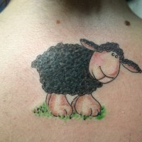 Tatuaje en la espalda,
oveja negra bonita en la hierba