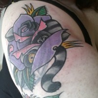 Tatuaje en el brazo,
lémur bonito con rosa púrpura