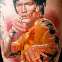 Graffiti style colored Bruce Lee portrait tattoo on thigh