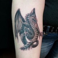 Great black-and-white winged dragon tattoo on forearm