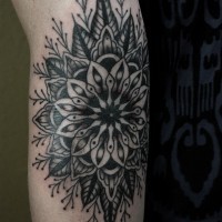 Great black-colored mandala flower tattoo on arm