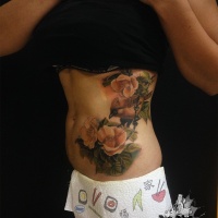 Gran tatuaje femenino con flores y pájaros