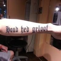 Great gothic-lettered quote tattoo on arm