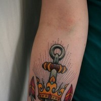 Great old school anchor pierced in golden crown tattoo on forearm