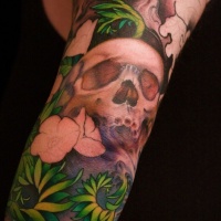 Green grass with skull tattoo on arm