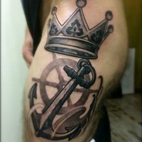 Harsh black-and-white anchor and crown tattoo on thigh