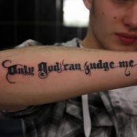 Tatuaje en el antebrazo, inscripción sólo Dios puede juzgarme, letra preciosa