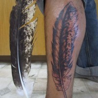 Huge eagle feather tattoo on leg