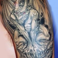 Illustrative style colored arm tattoo of gargoyle statue with red eyes