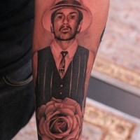 Tatuaje en el antebrazo,
retrato de un hombre caballero con rosa
