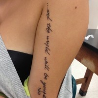 Incomplete black-lettered quote tattoo on arm