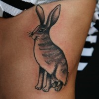 Interesting-designed black-and-white hare tattoo on side