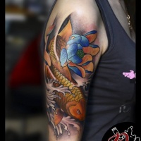 Peixe koi e tatuagem de flores no ombro