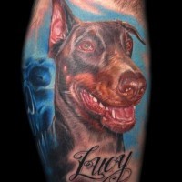 Large colorful doberman head on blue background with name quote tattoo on shin