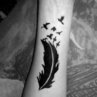 Tatuaje en el antebrazo, pluma negra encantadora
