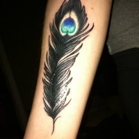 Tatuaje en el antebrazo,
pluma de pavo real negra magnífica