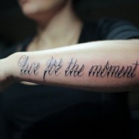 Tatuaje en el antebrazo, vive por el momento, letra grande