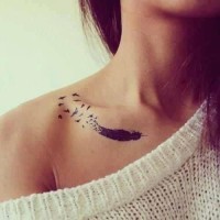 Tatuaje en el hombro, pluma negra con bandada de aves