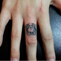 Lovely small black-and-white dog tattoo on finger