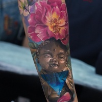 Nice Buddha and flowers tattoo on forearm