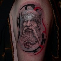 Tatuaje en el brazo,
vikingo en casco y ornamento tribal