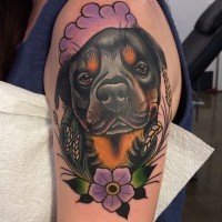 Oberarm Tattoo von Rottweiler  mit Blumen im altschulischen Stil