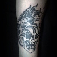 Old school style black ink arm tattoo of human skull with gargoyle