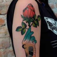 Old school style colored upper arm tattoo or green hand with rose