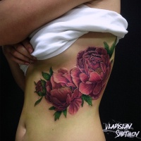 Tatuaje de flores rosadas en el costado