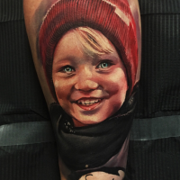 Portrait style colored tattoo of smiling boy