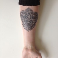 Pretty womens tribal heart-shaped tattoo on forearm