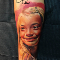 Foto real como tatuagem de antebraço colorido de menina sorridente