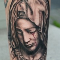 Religious black-and-white bleeding-eye Virgin Mary tattoo on forearm
