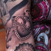Amerikanisches klassisches Tattoo mit sakralem Herzen am Arm