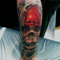Scary red black skull tattoo on leg
