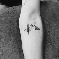 Tatuaje en el antebrazo, árbol con montañas y la luna, tinta gris