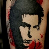 Simple painted in trash polka style upper arm tattoo of man portrait with lettering