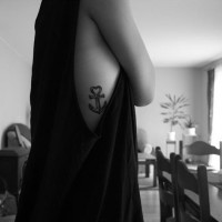 Simple tiny black-and-white anchor with heart on top tattoo on rib-side