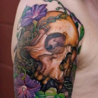 Skull and primrose flowers tattoo on shoulder