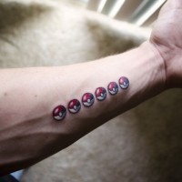Small funny colorful pocemon balls tattoo on forearm