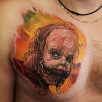 Small funny looking horror monster face tattoo on chest