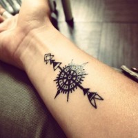 Small great black-ink compass tattoo on forearm