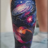 Tatuaje del tema espacial en la pierna