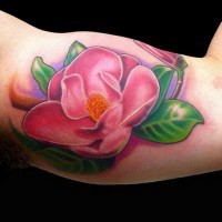 Tender little pink magnolia flower tattoo on upper arm