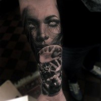 Terrible tatuaje de cara de mujer de terror en blanco y negro en el antebrazo