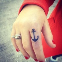 Thick-lined black anchor tattoo on forefinger