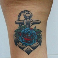 Tiny anchor with blue-and-red flower tattoo on thigh